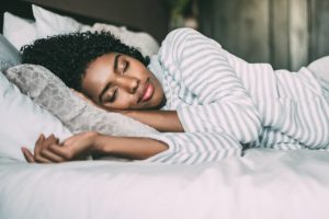 Woman sleeping in white bedspread