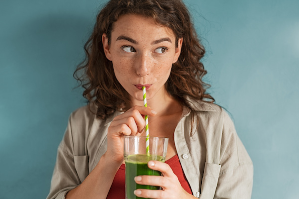 woman drinking green juice