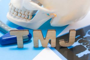 Human skull and TMJ wooden letters on blue counter