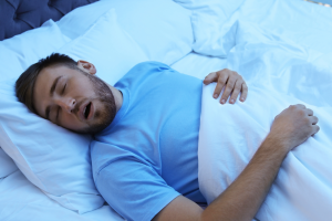 a person snoring while asleep in a bed