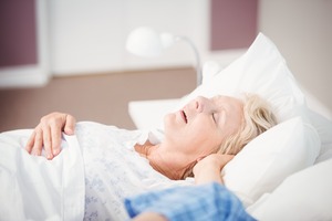 Older woman with sleep apnea snoring in bed